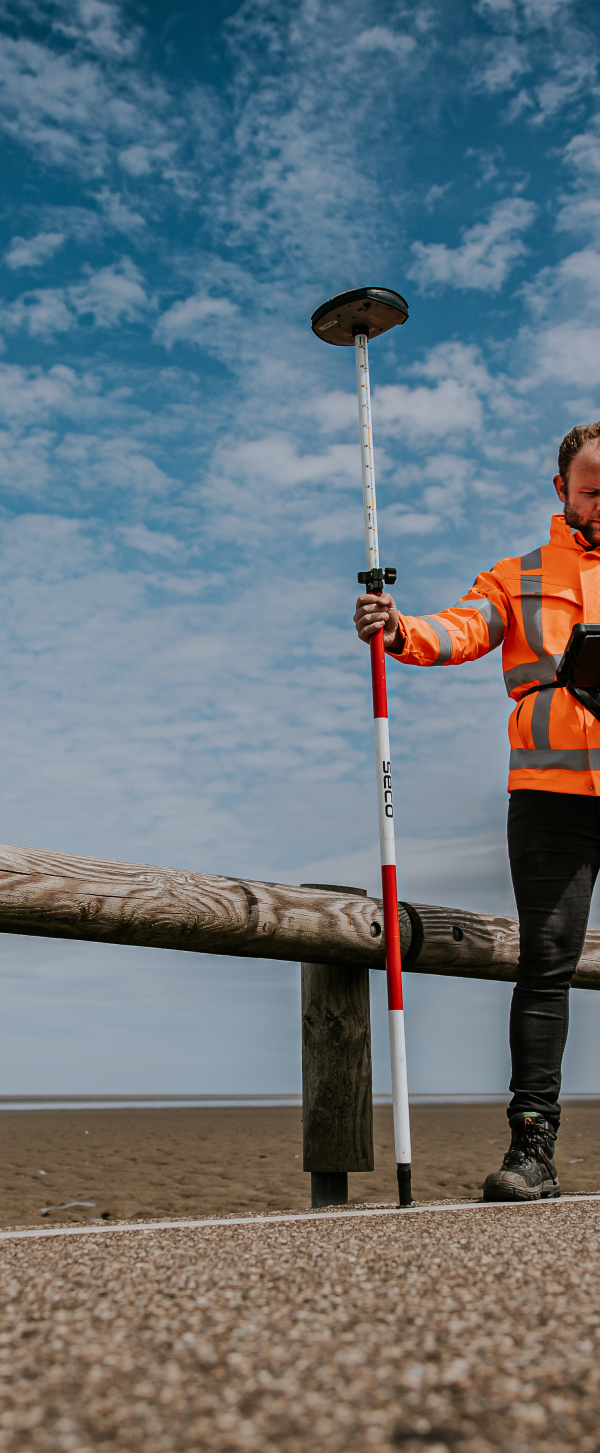 Man in oranje hesje voert een meting uit bij Veerhaven